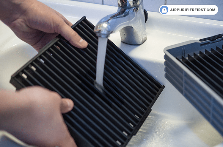 Washing collecting plate under the sink.